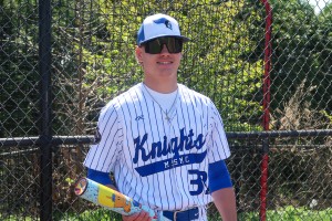 Baseball player stand with bat and smiles at Mount Saint Mary College. 