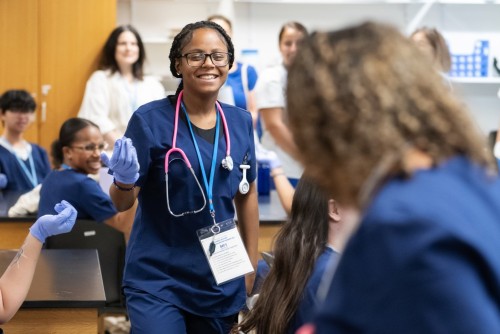 Student wearing scrubs in a science lab.