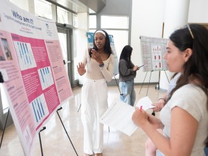 Two students in the Aquinas Atrium during an iROC poster presentation.