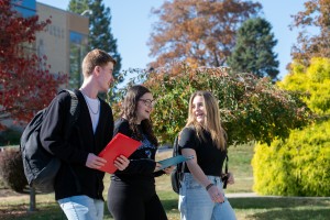 Three students walking on campus together.
