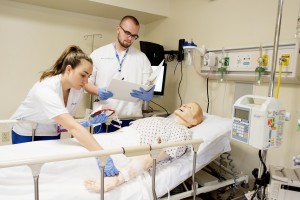 MSMC Nursing students work with simulation dummy in lab.