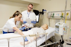 MSMC Nursing students work with simulation dummy in lab. 