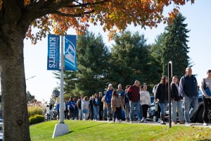 Group of prospective students and their families walking on a campus path. 