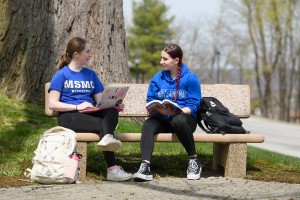 Two students sitting on a bench.