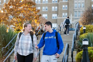 Two students walking down stairs together on a crisp fall day.