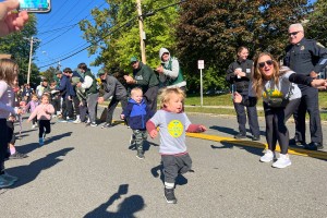ALT: Child runs down the street in the autumn time