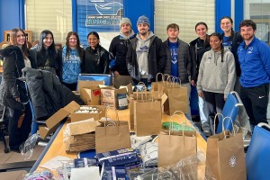 Mount Saint Mary College student-athletes – and Nyla Pichardo ’24, Resource Development Manager at Habitat for Humanity of Greater Newburgh (pictured far left) – assembled care packages containing essential supplies during a service project. 