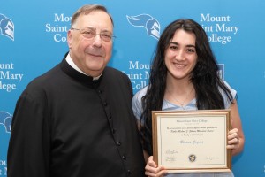 Mount Saint Mary College nursing graduate Bianca Cogoni ’25 is seen here with Fr. Greg Fluet, Vice President for Mission and Ministry, right after earning the Father Michael J. Gilleece Memorial Award for high moral character and service.