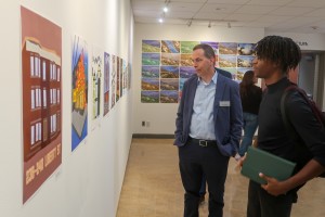 ALT: Two men observe art at Mount Saint Mary College