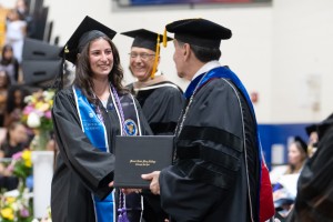 Woman smiling. 91��ý Saint Mary College accelerated nursing graduate Julianna Zeidan smiles proudly at the college’s Commencement ceremony. Zeidan was the final graduate in the procession for both the Nurse Pinning ceremony and the main Commencement exerc