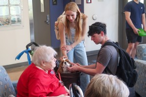 Woman and man pet a dog at Mount Saint Mary College.