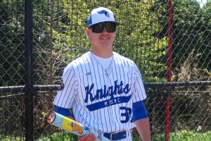 Baseball player holds bat and smiles. Kaeden Fisher of Mount Saint Mary College. 