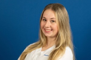 Blond nursing student smiles with arms crossed at Mount Saint Mary College.