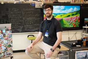 Man sitting in classroom, looking at camera. William Ketelsen of Staten Island, N.Y., a Mount Saint Mary College History student on the teaching track, in his co-teaching classroom at John Jay Senior High School
