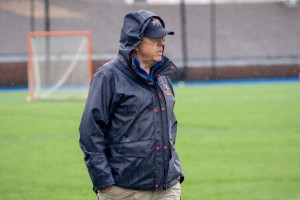 MAN STANDS IN RAIN AT MOUNT SAINT MARY COLLEGE.