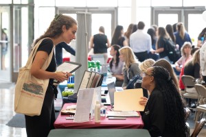 Woman looks at second woman, seated, at Mount Saint Mary College.