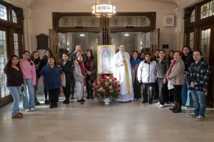 Fr. Gregoire Fluet (center), Vice President for Mission and Ministry at Mount Saint Mary College, joins students and community members around a portrait of Our Lady of Guadalupe, adorned with traditional red roses, during the college’s special Feast Day M