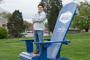 Man stands on giant blue chair. Senior Ryan Alvarado stands tall at Mount Saint Mary College as he prepares for graduation on May 16. After four years of balancing the soccer field, residence life leadership, and a rigorous Mathematics degree, the South B