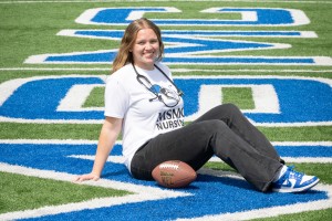 Woman on field with a football. 