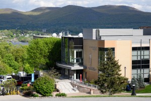 Mount Saint Mary College. Alt: A brown, tall building on a summer day, mountains stretching behind it.