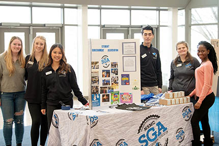 Students in SGA and Map standing in front of a poster board during a recent Involvement Fair held on campus.