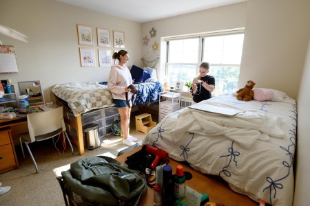 Two students setting up their dorm room.